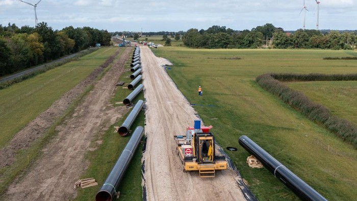 WILHELMSHAVEN, GERMANY - SEPTEMBER 13: In this aerial view workers construct a pipeline for transporting natural gas from the new, nearby liquified natural gas (LNG) terminal to the Etzel underground storage facility on September 13, 2022 near Wilhelmshaven, Germany. The new terminal will allow the docking of floating storage and regasification units (FSRU), which are ships that can convert liquified natural gas back into gas form and then deliver it directly into Germany's gas network and storage system. Natural gas from the Wilhelmshaven terminal will be sent through a 30km pipeline to the Etzel underground storage facility. The new terminal, scheduled for completion by the end of this year, will allow Germany to import LNG by ship from countries including the USA and Qatar in order to lower Germany's reliance on gas imports from Russia. (Photo by David Hecker/Getty Images)
