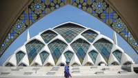 Pekerja melintas di depan pembangunan masjid yang telah rampung 60 persen dari keseluruhan. Direncanakan, masjid tersebut bisa diresmikan pada Desember 2022.