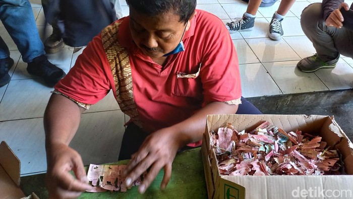 Samin, saat memperbaiki uangnya yang dimakan rayap, di SD Negeri Lojiwetan, Kelurahan Kedunglumbu, Kecamatan Pasarkliwon, Kota Solo, Rabu (14/9/2022).