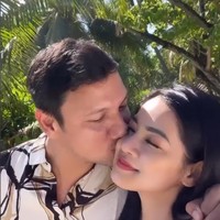 Christian Sugiono mendaratkan ciumannya ke Titi Kamal saat jalan bersama. Sang istri pun terkejut dengan aksi romantis suaminya itu. “Di kiss tiba2 ☺️. My love @csugiono,” tulisnya. Foto: Instagram/@titikamal
