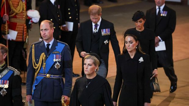 1243226282 LONDON, ENGLAND - SEPTEMBER 14: Prince William, Prince of Wales, Sophie, Countess of Wessex, Catherine, Princess of Wales, Prince Harry and Meghan, Duchess of Sussex walk as procession with the coffin of Britain's Queen Elizabeth arrives at Westminster Hall from Buckingham Palace for her lying in state on September 14, 2022 in London, United Kingdom. Queen Elizabeth II's coffin is taken in procession on a Gun Carriage of The King's Troop Royal Horse Artillery from Buckingham Palace to Westminster Hall where she will lay in state until the early morning of her funeral. Queen Elizabeth II died at Balmoral Castle in Scotland on September 8, 2022, and is succeeded by her eldest son, King Charles III. (Photo by Phil Noble - WPA Pool/Getty Images)