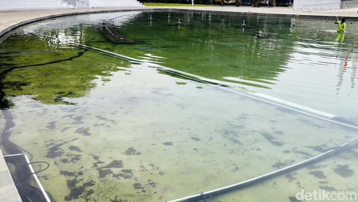 Petugas melakukan perawatan kolam air mancur di Lapangan Banteng, Jakarta. Petugas tampak nyebur ke kolam.
