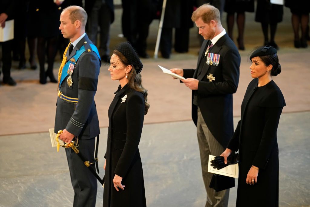 LONDON, ENGLAND - SEPTEMBER 14: Prince William, Prince of Wales, Catherine, Princess of Wales, Prince Harry, Duke of Sussex and Meghan, Duchess of Sussex seen inside the Palace of Westminster during the Lying-in State of Queen Elizabeth II on September 14, 2022 in London, England. Queen Elizabeth II's coffin is taken in procession on a Gun Carriage of The King's Troop Royal Horse Artillery from Buckingham Palace to Westminster Hall where she will lay in state until the early morning of her funeral. Queen Elizabeth II died at Balmoral Castle in Scotland on September 8, 2022, and is succeeded by her eldest son, King Charles III.  (Photo by Christopher Furlong/Getty Images)