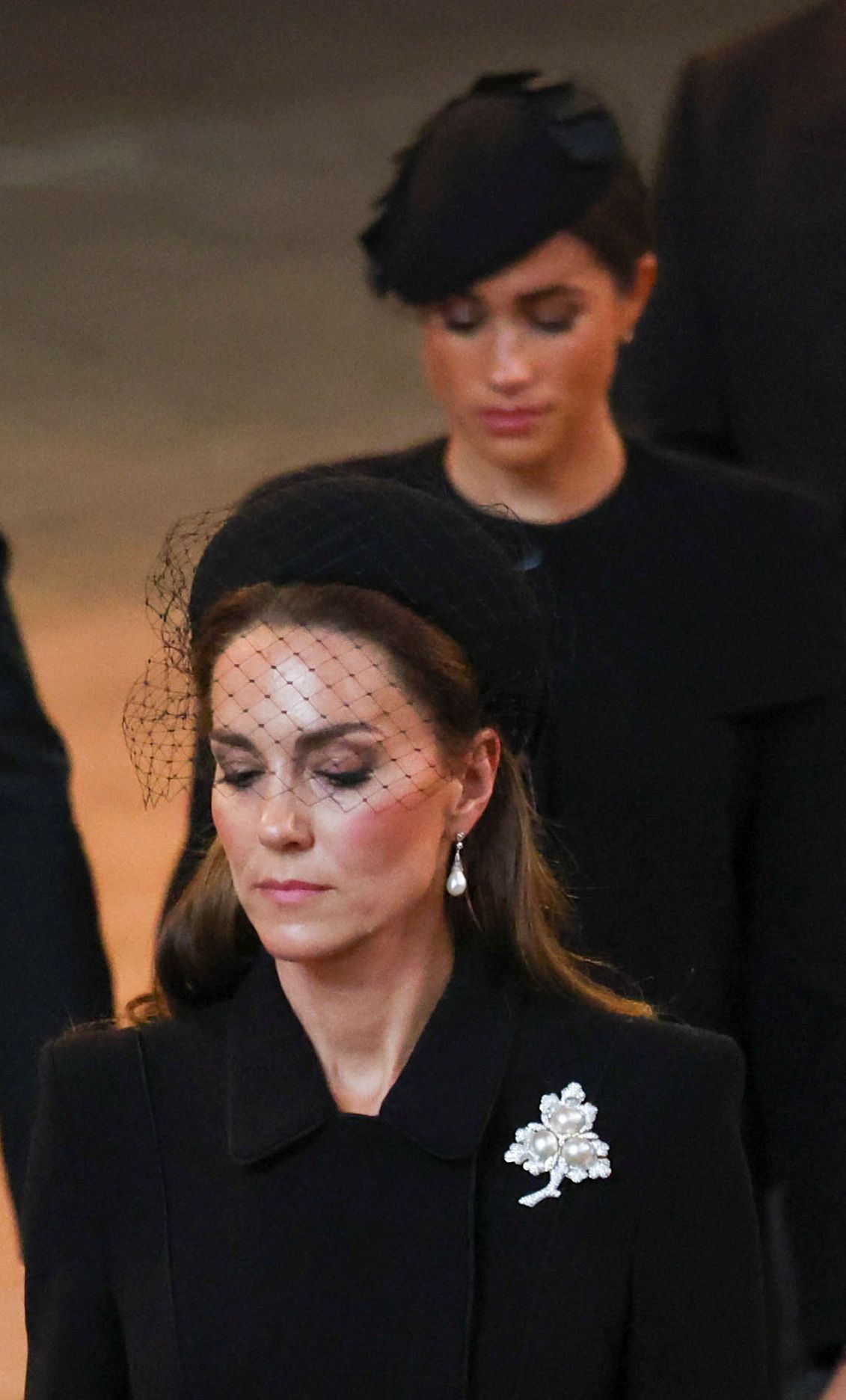 LONDON, ENGLAND - SEPTEMBER 14: Britain's Catherine, Princess of Wales and Meghan, Duchess of Sussex walk as procession with the coffin of Britain's Queen Elizabeth arrives at Westminster Hall from Buckingham Palace for her lying in state, on September 14, 2022 in London, England.  (Phil Noble - WPA Pool/Getty Images)