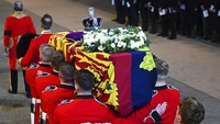 Selain mahkota, bagian atas peti tersebut juga diletakkan karangan bunga mawar putih serta dahlia. Oli Scarff/Pool via AP.