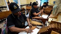 Tugasnya adalah mengukur dalam tabung logam tarikan setiap cerutu untuk memastikan bahwa perokok mendapatkan isapan yang sempurna.