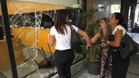 Karyawan bank yang panik berdiri di samping jendela yang dirusak oleh penyerang bank. Nadine Nakhal, seorang nasabah bank, mengatakan para penyusup menyiram bensin di mana-mana di dalam, dan mengeluarkan korek api dan mengancam akan menyalakannya. Dia mengatakan wanita dengan pistol mengancam akan menembak manajer jika dia tidak menerima uangnya.