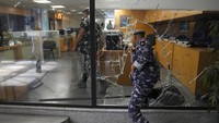Polisi Lebanon memasuki bank dari jendela yang dirusak oleh para nasabah yang menyerang bank BLOM. Hafez mengatakan dia memiliki total $20.000 dalam tabungan yang terperangkap di bank itu. 
