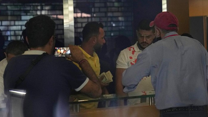 Nasabah Bank di Lebanon Nekat Ambil Paksa Tabungan Gegara Krisis Ekonomi A bank employee exits the bank through a window broken by attackers, in Beirut, Lebanon, Wednesday, Sept. 14, 2022. An armed woman and a dozen activists broke into a Beirut bank branch on Wednesday, taking over $13,000 from what she says were from her trapped savings. Lebanon's cash-strapped banks since 2019 have imposed strict limits on withdrawals of foreign currency, tying up the savings of millions of people. (AP Photo/Hussein Malla)