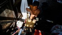 Seorang pekerja memasukan biji kedelai ke dalam mesin penggiling. Biji kedelai tersebut kemudian digiling menjadi bubur kedelai. Penggilingan bertujuan untuk memperkecil ukuran partikel kedelai sehingga akan mempermudah ekstraksi protein kedalam susu kedelai.