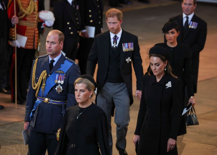 LONDON, ENGLAND - SEPTEMBER 14: Prince Harry and Meghan, Duchess of Sussex walk as procession with the coffin of Britains Queen Elizabeth arrives at Westminster Hall from Buckingham Palace for her lying in state on September 14, 2022 in London, United Kingdom. Queen Elizabeth IIs coffin is taken in procession on a Gun Carriage of The Kings Troop Royal Horse Artillery from Buckingham Palace to Westminster Hall where she will lay in state until the early morning of her funeral. Queen Elizabeth II died at Balmoral Castle in Scotland on September 8, 2022, and is succeeded by her eldest son, King Charles III. (Photo by Phil Noble - WPA Pool/Getty Images)