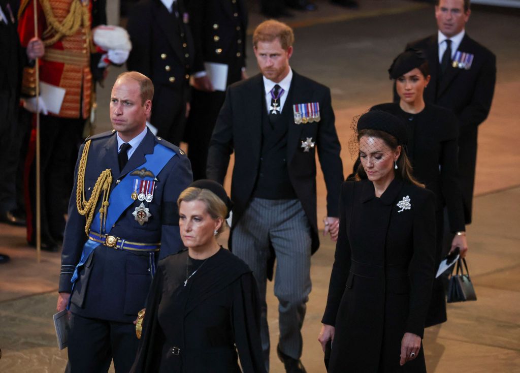 LONDON, ENGLAND - SEPTEMBER 14: Prince Harry and Meghan, Duchess of Sussex walk as procession with the coffin of Britain's Queen Elizabeth arrives at Westminster Hall from Buckingham Palace for her lying in state on September 14, 2022 in London, United Kingdom. Queen Elizabeth II's coffin is taken in procession on a Gun Carriage of The King's Troop Royal Horse Artillery from Buckingham Palace to Westminster Hall where she will lay in state until the early morning of her funeral. Queen Elizabeth II died at Balmoral Castle in Scotland on September 8, 2022, and is succeeded by her eldest son, King Charles III. (Photo by Phil Noble - WPA Pool/Getty Images)