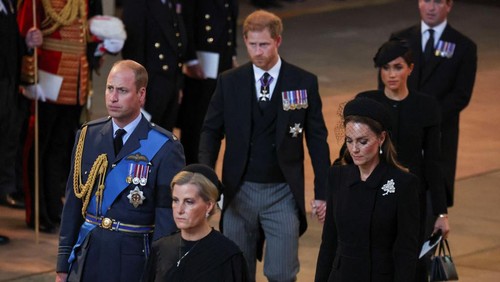 LONDON, ENGLAND - SEPTEMBER 14: Prince Harry and Meghan, Duchess of Sussex walk as procession with the coffin of Britains Queen Elizabeth arrives at Westminster Hall from Buckingham Palace for her lying in state on September 14, 2022 in London, United Kingdom. Queen Elizabeth IIs coffin is taken in procession on a Gun Carriage of The Kings Troop Royal Horse Artillery from Buckingham Palace to Westminster Hall where she will lay in state until the early morning of her funeral. Queen Elizabeth II died at Balmoral Castle in Scotland on September 8, 2022, and is succeeded by her eldest son, King Charles III. (Photo by Phil Noble - WPA Pool/Getty Images)