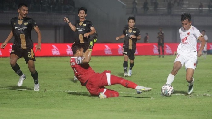 Pemain PSM Makassar Ricky Pratama mengelabui Kiper Dewa United M Natshir
