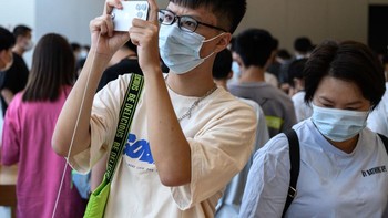 Pengunjung mencoba kamera iPhone 14. Foto: Getty Images