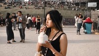 Begini momen Audrey saat menikmati es kelapa yang segar. Ia tampak berpose di tengah orang-orang banyak. Foto: Instagram @audreyyvanessa