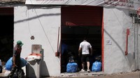 Seorang pria berjalan di layanan Drive Throw di fasilitas pemilahan dan daur ulang Pengelolaan Sampah Lebanon di Bauchrieh. Beberapa pengguna layanan dapat menyumbangkan uang yang dihasilkan dari sampah ke badan amal lokal yang mendukung orang tua, pasien kanker dari bank makanan.