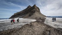 Sejumlah turis berjalan di celah Tsanfleuron dengan lapisan es sangat tipis di Gletser 3000, Swiss, Selasa, (13/9/2022).
