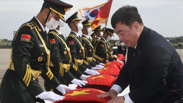 Chinese Ambassador to South Korea Xing Haiming (R) places his countrys flag over caskets containing the remains of Chinese soldiers killed in the Korean War, during the handing over ceremony at South Koreas Incheon International Airport SONG Kyung-Seok AFP