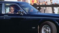Foto Ratu Elizabeth II mengemudi Mobil Daimler Jaguar-nya sendiri saat tiba di Smiths Lawn, Windsor untuk menonton pertunjukkan polo. (Tim Graham Photo Library/Getty Images)
