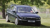 Momen saat Ratu Elizabeth II menyaksikan Land Rover International Driving Grand Prix dari mobil estate Jaguar X Type barunya di Windsor, Inggris, 11 Mei 2006. (Tim Graham Photo Library/Getty Images)