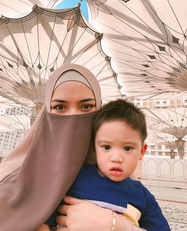 Ciki berpose selfie memakai cadar sambil memangku Athar. Warganet kagum dengan kecantikan Ciki saat memakai cadar. Mamcit pake niqob pantes dan cantik bangetttt.. puji akun @dhiamelia07. Cantik banget ka...asli cantik ❤️❤️ ditambah mas Athar yang super ganteng ❤️❤️, puji akun @kalea.03. Foto: Dok. Instagram @citraciki.