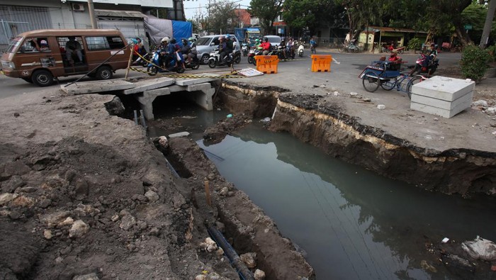 PEMBANGUNAN SALURAN AIR DI SURABAYA Pengguna jalan melintas di dekat pengerjaan saluran air di Jalan Kayoon, Surabaya, Jawa Timur, Jumat (16/9/2022). Pemkot Surabaya melakukan pembangunan saluran-saluran air di sejumlah lokasi untuk mengantisipasi banjir saat musim hujan. ANTARA FOTO/Didik Suhartono/rwa.