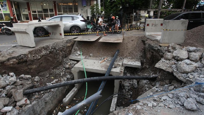 PEMBANGUNAN SALURAN AIR DI SURABAYA Pengguna jalan melintas di dekat pengerjaan saluran air di Jalan Kayoon, Surabaya, Jawa Timur, Jumat (16/9/2022). Pemkot Surabaya melakukan pembangunan saluran-saluran air di sejumlah lokasi untuk mengantisipasi banjir saat musim hujan. ANTARA FOTO/Didik Suhartono/rwa.
