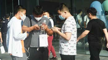 Mungkin para fanboy Apple di Hangzhou ini sedang membicarakan fitur iPhone 14. Foto: Getty Images