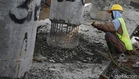 Seorang pekerja melakukan pemotongan tiang beton (slab on pile ) yang sudah tertanam. Perbaikan Jembatan Sodong ditargetkan akan selesai sebelum Nataru (Natal Tahun Baru).