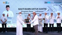 Asisten Deputi Bidang Tanggung Jawab Sosial dan Lingkungan (TJSL) Kementerian BUMN Edi Eko Cahyono menyerahkan modul Vokasi kepada salah satu peserta Training of Trainer (ToT) pada kegiatan kick off Program Bakti BUMN untuk Santri.