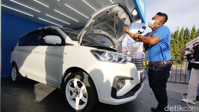 Salah satu inspektor mobil menunjukkan cara kroscek unit mobil bekas di GIIAS Surabaya 2022.