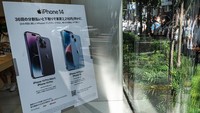 Members of security stand at the entrance to an Apple store as customers queue up for the launch of the new iPhone 14 in Tokyo on September 16, 2022. (Photo by Richard A. Brooks / AFP) (Photo by RICHARD A. BROOKS/AFP via Getty Images)