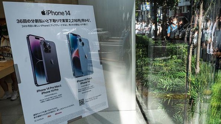 Members of security stand at the entrance to an Apple store as customers queue up for the launch of the new iPhone 14 in Tokyo on September 16, 2022. (Photo by Richard A. Brooks / AFP) (Photo by RICHARD A. BROOKS/AFP via Getty Images)