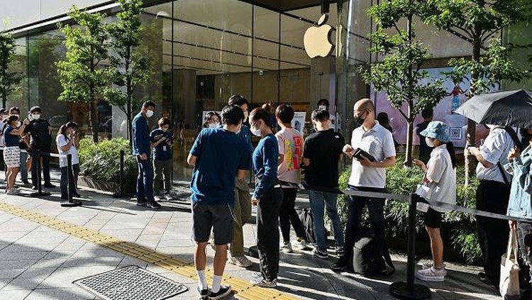 Members of security stand at the entrance to an Apple store as customers queue up for the launch of the new iPhone 14 in Tokyo on September 16, 2022. (Photo by Richard A. Brooks / AFP) (Photo by RICHARD A. BROOKS/AFP via Getty Images)