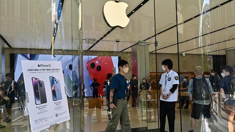 Members of security stand at the entrance to an Apple store as customers queue up for the launch of the new iPhone 14 in Tokyo on September 16, 2022. (Photo by Richard A. Brooks / AFP) (Photo by RICHARD A. BROOKS/AFP via Getty Images)