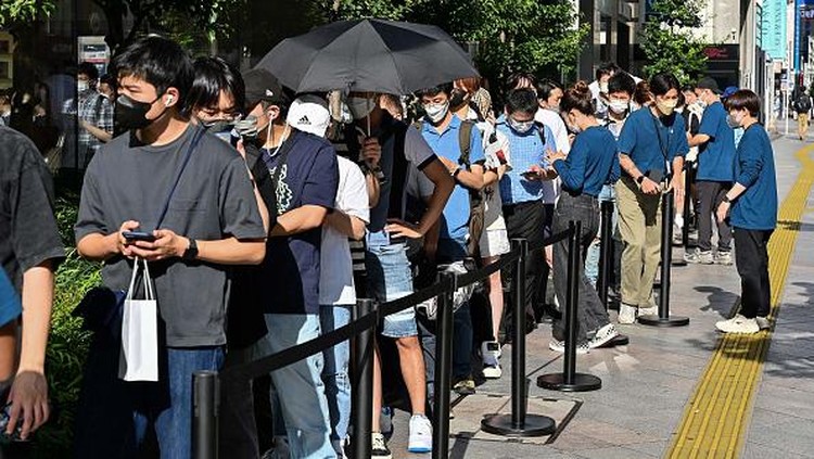 Sambutan Antusias iPhone 14 Saat Rilis di Jepang dan China Members of security stand at the entrance to an Apple store as customers queue up for the launch of the new iPhone 14 in Tokyo on September 16, 2022. (Photo by Richard A. Brooks / AFP) (Photo by RICHARD A. BROOKS/AFP via Getty Images)