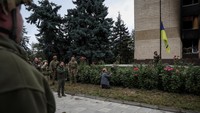 Presiden Ukraina Volodymyr Zelenskiy menyanyikan lagu kebangsaan saat menghadiri upacara pengibaran bendera nasional selama kunjungannya di kota Izium, yang baru saja dibebaskan oleh Angkatan Bersenjata Ukraina.