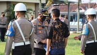 Kapolres Lampung Tengah AKBP Doffie Pahlevi saat memakaikan baju batik ke Rudi. Eks Kanit Provos Polsek Way Penghubuan itu dipecat tak hormat, Rudi pun terancam hukuman mati karena melakukan pembunuhan berencana ke rekannya sesama polisi. (Foto: Istimewa)