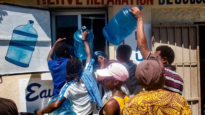 BBM Mahal, Warga Haiti Juga Antre Air dan LPG PORT-AU-PRINCE, HAITI - SEPTEMBER 15: People carry a gas cylinders to refill as protesters continue demonstration on the third day of mobilization over fuel price hikes in Port-au-Prince, Haiti on September 15, 2022. (Photo by Georges Harry Rouzier/Anadolu Agency via Getty Images)