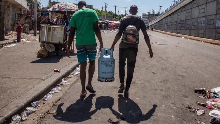BBM Mahal, Warga Haiti Juga Antre Air dan LPG PORT-AU-PRINCE, HAITI - SEPTEMBER 15: People carry a gas cylinders to refill as protesters continue demonstration on the third day of mobilization over fuel price hikes in Port-au-Prince, Haiti on September 15, 2022. (Photo by Georges Harry Rouzier/Anadolu Agency via Getty Images)