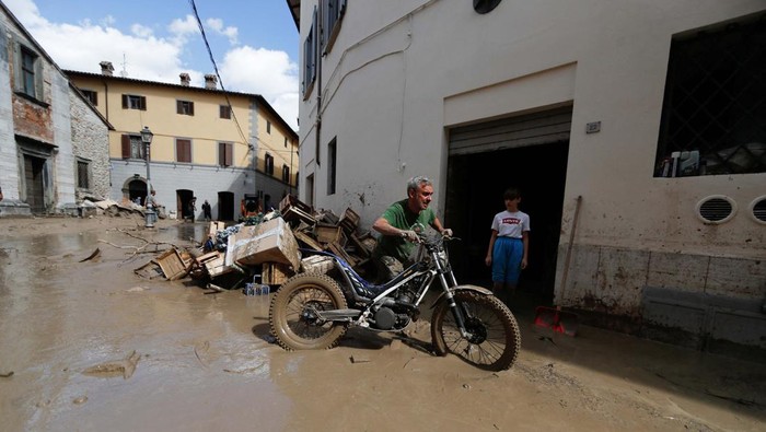People help an elderly woman after heavy rains and deadly floods hit the central Italian region of Marche, in Cantiano, Italy, September 16, 2022. REUTERS/Yara Nardi TPX IMAGES OF THE DAY