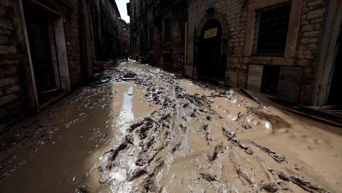 People help an elderly woman after heavy rains and deadly floods hit the central Italian region of Marche, in Cantiano, Italy, September 16, 2022. REUTERS/Yara Nardi     TPX IMAGES OF THE DAY