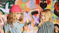 Margot Robbie dan Cara Delevingne saat menyelesaikan mural karya Ryan Meades di London, Inggris.  Foto: Getty Images/David M. Benett