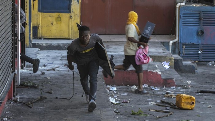 Protes BBM Naik, Warga Haiti Lakukan Penjarahan Toko Polices secure a gas station during a protest against fuel price hikes and to demand that Haitian Prime Minister Ariel Henry step down, in Port-au-Prince, Haiti, Friday, Sept. 16, 2022. (AP Photo/Odelyn Joseph)