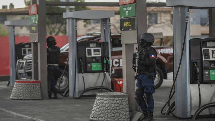 Protes BBM Naik, Warga Haiti Lakukan Penjarahan Toko Polices secure a gas station during a protest against fuel price hikes and to demand that Haitian Prime Minister Ariel Henry step down, in Port-au-Prince, Haiti, Friday, Sept. 16, 2022. (AP Photo/Odelyn Joseph)