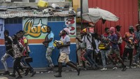 Para pengunjuk rasa membawa barang-barang jarahan selama protes terhadap kenaikan harga bahan bakar dan menuntut Perdana Menteri Haiti Ariel Henry mundur, di Port-au-Prince, Haiti, Jumat, 16 September 2022.