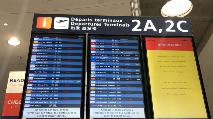 PARIS, FRANCE - SEPTEMBER 16: People check a screen displaying cancelled and delayed fliights at Paris Charles De Gaulle International Airport as air traffic controllers go on a strike with the call of French air traffic control union (SNCTA) in Paris, France on September 16, 2022. French air traffic controllers' strike forced airlines to cancel half of those scheduled to arrive or depart Paris airports and others due to have flown over France. (Photo by Esra Taskin/Anadolu Agency via Getty Images)
