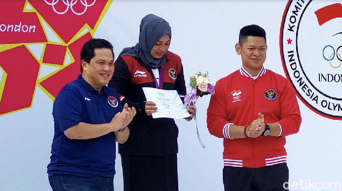 Lifter Citra Febrianti dalam prosesi pengalungan medali perak kelas 53 kg putri Olimpiade 2012 dari International Olympic Committee Member Erick Thohir, di Kompleks Gelora Bung Karno, Senayan, Minggu (18/9/2022).