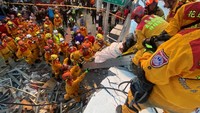 Petugas pemadam kebakaran berhasil mengevakuasi warga yang terjebak di reruntuhan gedung, Minggu (18/9/2022).